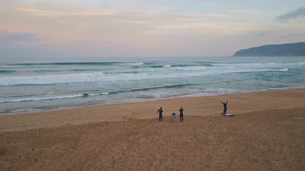 冲浪者在海滩鸟瞰上热身 花哨的泡沫浪花在美丽的沙滩上飞溅 动作非常缓慢 难以辨认的人将在夏夜的暴风雨中冲浪 — 图库视频影像