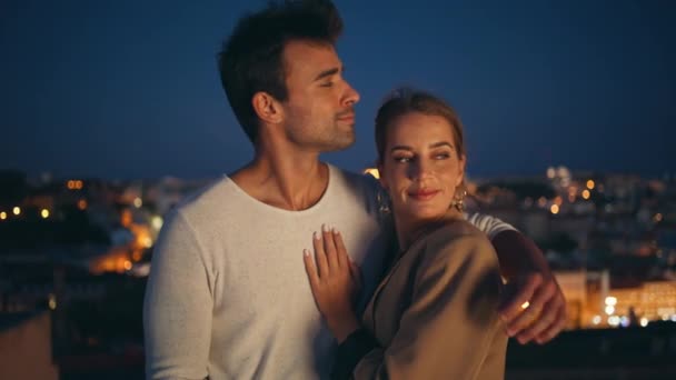 在夜市的彩灯特写中 有一个男人正在亲吻一个表达爱意的女人 恋恋不舍的夫妻一起拥抱晚上的约会 微笑迷人的情人拥抱在一起享受这一刻的关系 — 图库视频影像