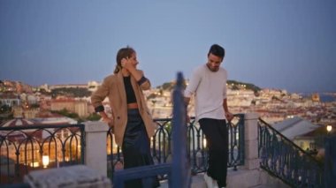 Gece şehir manzarasında ilk buluşmada konuşan bir çift. Mutlu çiftler yazın şehrin ışıklarında akşam flörtleşmelerinin keyfini çıkarıyorlar. Gülümseyen utangaç erkek kadın bakış açısıyla dışarıda hoş sohbetler yapıyor..