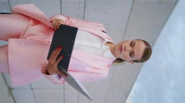 İşletme müdürü, belgeleri dikey olarak elinde tutuyor. Şehir duvarının yanında yürüyen zarif bir iş kadını dosyaları ile klasörü kapatıyor. Bayan CEO 'su acilen ofise gittiğini bildiriyor.