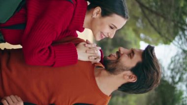 Sırt çantaları dikey bir şekilde ormanda duran sevimli genç çift. Dışarıda gülümseyen sakallı adamı öpen genç bir kadın. Birbirine aşık iki mutlu insan güzel doğada yürüyüş yapmaktan zevk alır.. 