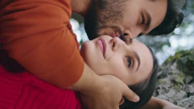 Yakışıklı bir adam genç bir kadının yüzünü okşuyor. Dikey ormanda dikey bir melek gibi dikiliyor. Sakallı adam kızı doğada öpüyor. Romantik hafta sonunun tadını çıkaran mutlu bir çift. Tarih kavramı.