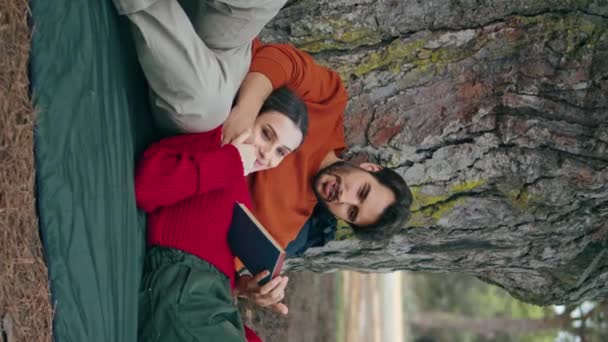 Entspanntes Junges Paar Auf Picknickdecke Unter Breitem Baum Senkrecht Liegend — Stockvideo