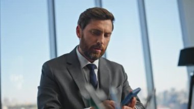 Profesyonel olarak akıllı telefon mesajlarını kontrol etmekle meşgul. Masa başında evrakları imzalayan yakın kişiler. Çağdaş ofiste cep telefonuyla çalışan başarılı bir şirket patronu. Sakallı yönetici yönetici