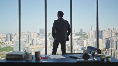 Müdür Silueti panoramik ofis dikiz aynasından şehri inceliyor. Takım elbiseli sakin şirket CEO 'su tek başına pencereye bakmayı düşünüyor. Başarılı profesyonel siluet iş yerinde geleceği düşünmeyi hayal ediyor..