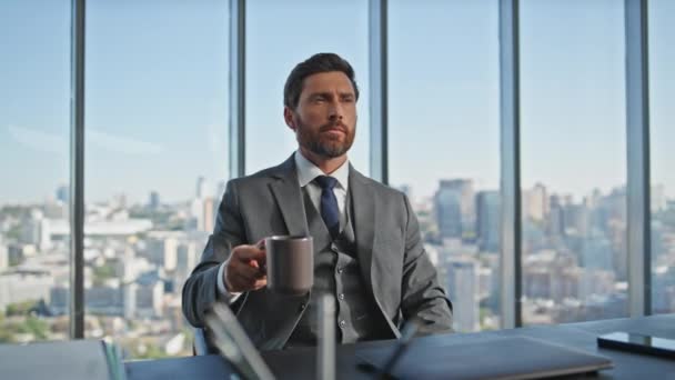 デスクでビジネスアイデアを考える成功したマネージャー パノラマオフィスのコーポレート問題を熟考するコーヒーカップを保持する中年経営者 自信を持ってビジネスマン計画プロジェクト開発 — ストック動画
