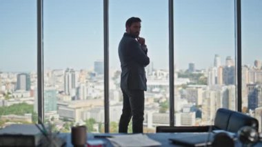 Şehir manzarasında yönetici görünümlü ofis penceresi. Başarılı bir menajer, iş kararı veren sözleşme kağıtlarını imzalar. İnsan silueti, gelecekteki gelişmeyi düşünerek ayakta duruyor. Liderlik stratejisi kavramı