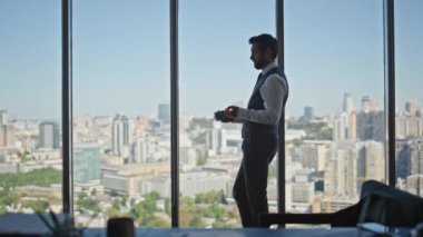 Panoramik pencerede kurumsal danışman tefekkür sorunu. Başarılı bir CEO 'ydu. Geleceği planlayan iş fikirleri düşünüyordu. Profesyonel yönetici dinleniyor. Ofiste müşteri toplantısı var.