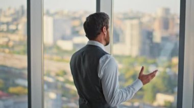 Başarılı yönetmen panoramik pencerede akıllı telefonlardan konuşuyor. Finans müdürü, danışman müvekkili çağdaş ofiste arıyor. Yakışıklı sakallı yönetici cep telefonuyla iş görüşmesi yapıyor..