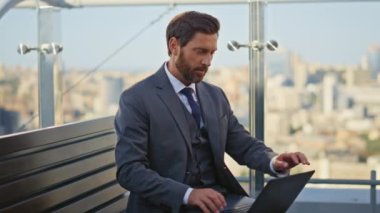 Şehir terasında uzaktan kumandalı bir iş adamı dizüstü bilgisayar kullanıyor. Rahat adam balkonda tek başına kahve içmeyi bitir. Sakin, takım elbiseli yakışıklı yönetici mola içkisini yudumluyor. Huzurlu yönetici dinleniyor.