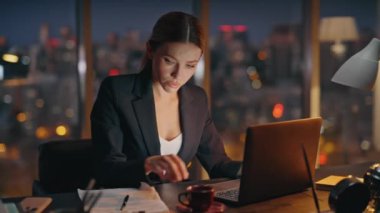 Sinirli kadın geç saatlere kadar mali raporları tek başına analiz ediyor. Stresli yönetici karanlık ofiste fazla mesai kağıtlarını kontrol ediyor. Endişeli çalışan mutsuz iş kadını sorunu akşam çözüyor.