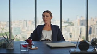 Panoramik manzarada sakin bir iş kadını dinlenme masası. Düşünceli kadın mola alıp modern ofiste bekliyor. Güzel, ciddi bir işçi düşünme problemi. İşinde başarılı bir şirket kadını..