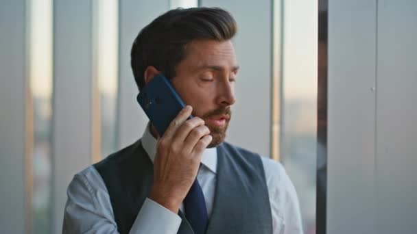 パノラマのオフィスの窓で携帯電話を話すポートレートの自信を持ったリーダー ビジネス上の問題について話し合うハンサムな男性コンサルタント 成功した中年銀行家ビジネスマン話しセル — ストック動画