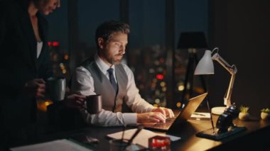 Gece çalışanları masadaki bilgisayarı tarıyor. Gülümseyen kadın ortak kahve getiriyor ve karanlık ofiste şirket satış raporları hakkında konuşuyor. İş arkadaşları dizüstü bilgisayarda çalışıp yaratıcı projeyi tartışıyor..