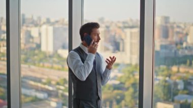 Panoramik ofiste telefon görüşmesi yapan bir yönetici. Sakallı avukat yönetici iş projesini telefonda ortağıyla tartışıyor. Şehir merkezinde ciddi orta yaşlı profesyonel CEO görüşmeleri.