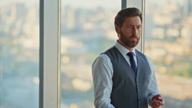 Ofiste düşünceli bir yönetici yürüyor. Gergin şirket lideri panoramik pencereye top atıp kafa yoruyor. Yakışıklı, stresli, şehir manzaralı girişimci rüyası. CEO karar veriyor.