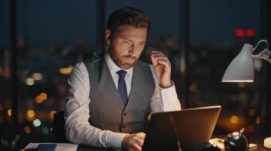 Finans müdürü gece ofisinde daktilo yazıyor. Yorgun adam gece geç saatlerde bilgisayar başında çalışıyor. İşyeri çalışanlarının iş yerindeki bilgisayarları karıştırması bunaltıcı. Şirket iş kavramı.