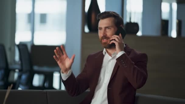 ビッグオフィスのインテリアで携帯電話を話す陽気なビジネスマン コーポレートホールで金融プロジェクトで働く喜びの起業家 Ceo Smartfoneを使用してマーケティングプランを議論する幸せな幹部 — ストック動画