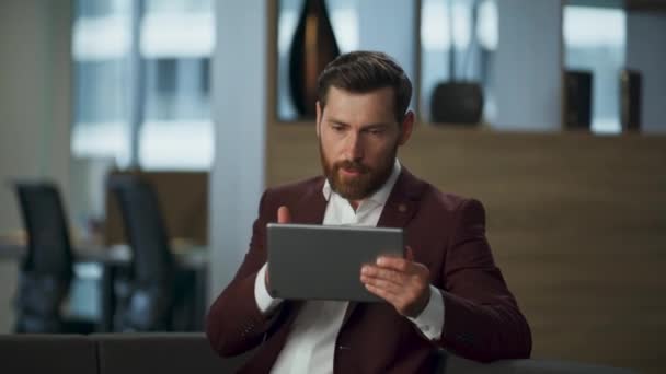大きいキャビネットの指のタブレット コンピュータ スクリーンを指す怒っている起業家 オフィスの内部で重要なビデオ会議を持っている真剣なビジネスマン プロのリアクターデジタルミーティングコンセプト — ストック動画