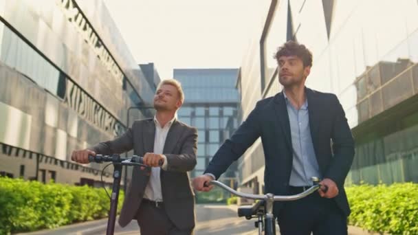시내에서 스쿠터 자전거를 비즈니스 관리자 사람들은 사무실 건물에서 거리를 아침에 — 비디오