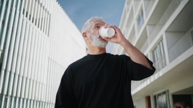 Sabah adamı şehir merkezinde kahve içiyor. Son sınıf erkek gazete okuyor ve yaz yürüyüşünün tadını çıkarıyor. Başarılı, stressiz, gri saçlı girişimci haberleri kontrol ediyor. Şık yaşlı iş adamı.