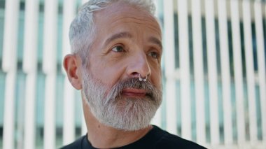 Sokakta sabah kahvesi içen olgun bir adamın portresi. Gri saçlı, piercing takan ve içkinin tadını çıkaran vahşi bir erkek. İyi görünümlü son sınıf istirahati yudumlarken dışarıda dinleniyor. Yaşam tarzı rutin kavramı