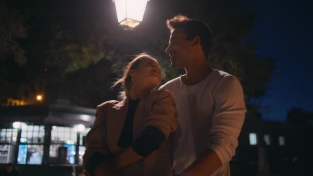 约会情侣拥抱夜晚的城市 快乐的男人旋转着深情的女人一起享受夜晚 可爱的情人们 已婚的人在灯柱下亲吻拥抱 幸福关系 — 图库视频影像