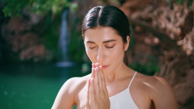 Turkuaz göl doğasında meditasyon yapan namaste hareketi. Rahatlamış yogacı kadın göğüs röntgenine el sıkışıyor. Huzurlu bayan uyumu hissediyor güneş ışınları ormanlarında meditasyon yapıyor 