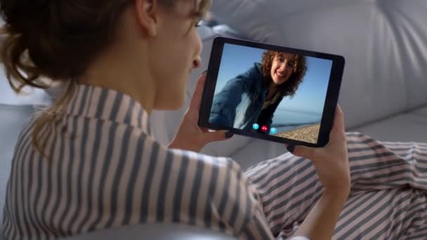 女孩在线聊天平板室内特写 旅途愉快的朋友在网上打电话 一个不知名的女人用电脑摄像头的肩景图聊天 快乐的微笑伴侣挥手 — 图库视频影像