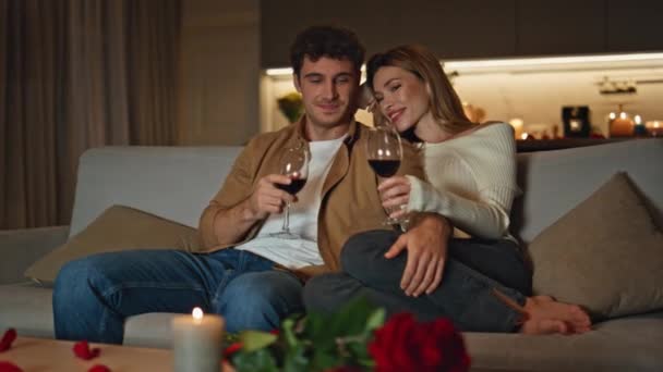 爱家的人在浪漫的家约会时碰杯 微笑的配偶们在舒适的沙发上放松地喝着美味的葡萄酒 温柔的情人带着蜡烛在公寓里共度夜晚 爱情的概念 — 图库视频影像