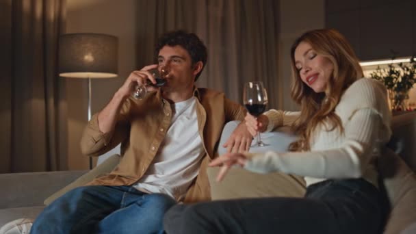 Zrelaksowana Para Pijąca Wino Wygodnej Kanapie Domowej Beztroska Młoda Para — Wideo stockowe