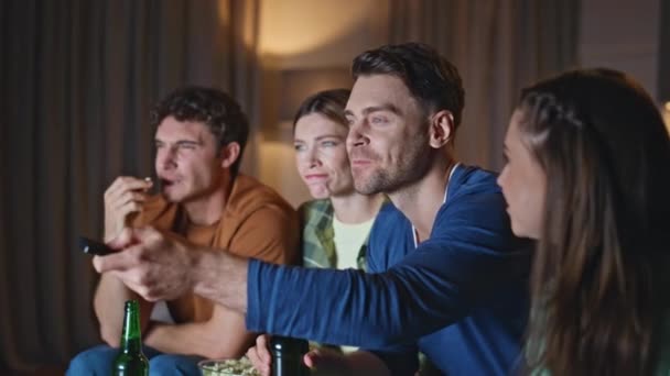 Przyjazni Ludzie Włączają Kanał Telewizyjny Przytulnym Salonie Grupa Zrelaksowanych Przyjaciół — Wideo stockowe
