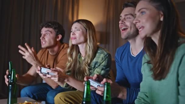 晚上客厅里玩电子游戏的人都很失望 不满意的朋友在竞争中的情绪反应在家里失败了 在周末出去玩的时候 一群年轻的游戏玩家拿着游戏机 — 图库视频影像