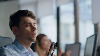 Ajan Hand monitörden kulaklığı alıyor. Dost canlısı bir yardım hattı yöneticisi danışman bir müşteriyle konuşuyor. Çağrı merkezinde çalışan profesyonel teknik asistan bilgisayar görüntüsü. Müşteri desteği işi