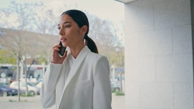 Şehir merkezinde telefonla konuşan ciddi bir kız. Endişeli kadın iş konularını dışarıda partnerle konuşuyor. Şık iş kadını telefon görüşmesi yapıyor..