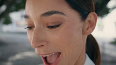 Kameraya bakıp gülen heyecanlı zarif bir kadının portresi. Neşeli kız suratı hayret verici bir şekilde ağzını kapatıyor. Duygusal, neşeli esmer, mutluluğu hisseden açık havada sevinen sürpriz.