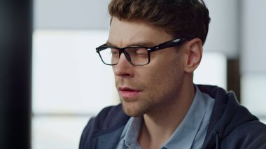 Çevrimiçi raporları kontrol eden adama odaklandım. Gözlüklü düşünceli bir işadamı, sorun çözme arayışında. Bilgisayarda çalışıyor. Odaklanmış proje yöneticisi programcısı hata bulmayı düşünüyor