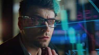 Yakından gelen adam holografik istatistikleri analiz ediyor. Düşünceli borsa simsarının karanlık işyerinde kâr stratejisi planlaması. Fütürist profesyonel yönetici veri arama yatırım fikrini hesaplıyor