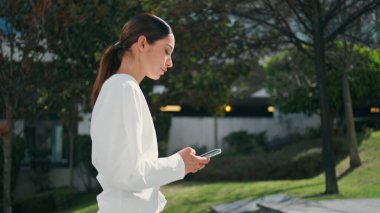 Lüks esmer kız merdivenlerden çıkarken gülümsüyor ve telefon ekranına bakıyor. Yan manzara, mutlu iş kadını yukarıda akıllı telefondan sohbet ediyor. Rahat kız gezintide telefon kullanıyor.