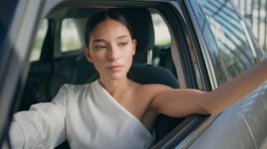 Araba direksiyonunda başarılı bir bayan var. Kendine güvenen güzel iş kadınının portresi açık araç penceresinde el ele poz veriyor. Pahalı otomobilin içinde kameraya bakan muhteşem ciddi bir kadın..