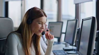Gülümseyen servis operatörü bilgisayarda çalışıyor. Dost canlısı bir kadın telefonda kulaklık danışmanı müşteri ile konuşuyor. Güzel pazarlama müdürü ofiste müşteriyle konuşuyor. Neşeli teknik satış asistanı