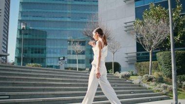 İş kadını şehir parkında telefonla sesli mesaj kaydediyor. Akıllı telefon hoparlöründe konuşan zarif bir iş kadını. Harika bir esmer, mikrofonla konuşuyor. İşe gidiyor.