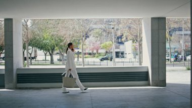 Modern ofis binasında yürüyen zengin bir kadın akıllı telefondan konuşuyor. Zarif beyaz takım elbiseli muhteşem bir iş kadını iş ortaklarını toplantıya çağırıyor. Meşgul bayan yönetici telefon görüşmesi yapıyor.