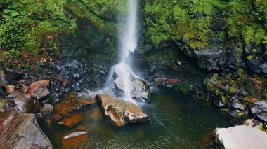 Şelale akıntısı hava manzaralı kayalara çarpıyor. Yosunlu kayalıklardan akan güçlü su nehir arazisine düşüyor. Tehlikeli soğuk sıvı, su sıçratan tepeler. Destansı ölçek doğa kavramı