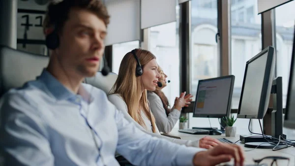 Call center team working in office. Friendly operators talk consulting clients in headset. Thoughtful man technical assistant listening customer contemplating problem. Professional helpdesk teamwork