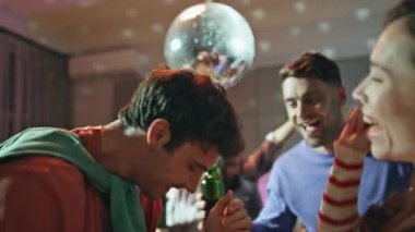 Parti evinde dans eden heyecanlı arkadaşlar yanan disko topunu yakın çekime alın. Mutlu gençler ellerinde bira şişeleriyle hafta sonları eğleniyorlar. Güler yüzlü arkadaşlar gece birlikte eğleniyorlar..