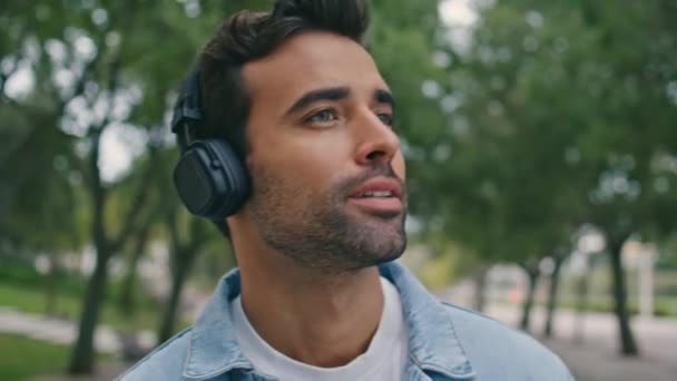 Güzel Yeşil Şehir Bahçesinde Kablosuz Kulaklıkla Müzik Dinleyen Yakışıklı Bir — Stok video