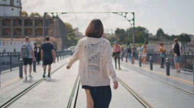 Summer City 'nin arka manzarasında şık bir kadın yürüyor. Rahat esmer kız güzel şehir manzarasında aşırı kalabalık caddeye çıkıyor. Sakin model tramvaya tek başına bakıyor. Şehir hayatı konsepti
