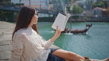 River Bank 'ta roman okuyan romantik kız zum yapıyor. Odaklanmış bir kadın hafta sonu hobisinin keyfini çıkarıyor. Dışarıda kitap edebiyatı okuyan güzel bir bayan var. Rahatlama rahatlama konsepti