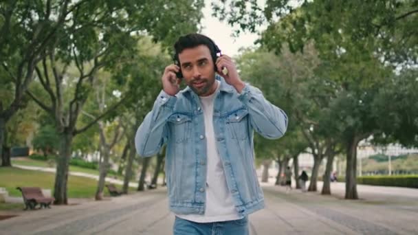 Латинський Хіпстер Слухає Музику Допомогою Бездротових Навушників Йдуть Красивим Зеленим — стокове відео
